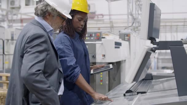 Svart kvinnlig fabriksingenjör visar nya maskiner — Stockvideo
