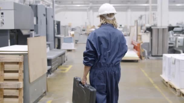 Ingeniera de fábrica femenina con caja de herramientas caminando en el piso de la planta — Vídeos de Stock