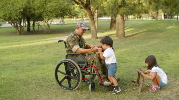 Glada barn njuter av fritid med handikappade militär pappa — Stockvideo
