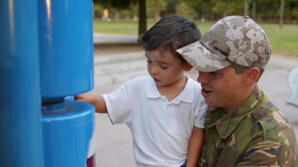 Militär pappa tillbringar fritid med lille son i parken — Stockvideo