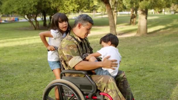 Parkta çocuklarla oynayan engelli asker baba. — Stok video