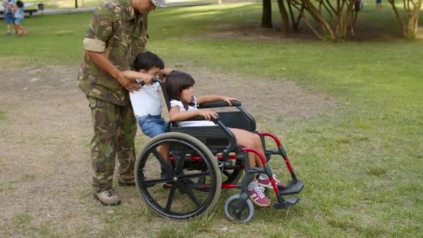 Padre militar caminando con hijo e hija discapacitada — Vídeo de stock