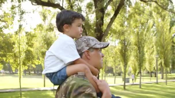 Parkta babasının omuzlarına binen küçük mutlu çocuk. — Stok video