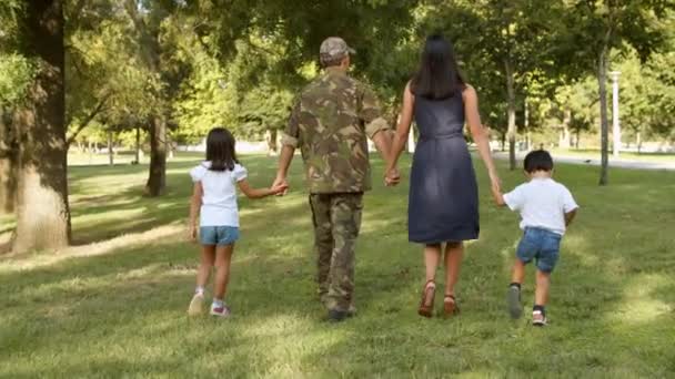 Vojenský muž a jeho rodina se těší volný čas v parku — Stock video