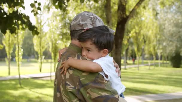 Щасливий військовий тато тримає сина в руках на відкритому повітрі — стокове відео