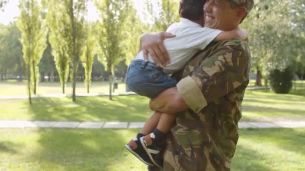 Aufgeregter Junge läuft Soldatenpapa mit offenen Armen entgegen — Stockvideo