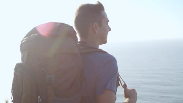 Felice maschio backpacker in piedi a scogliera rocciosa — Video Stock