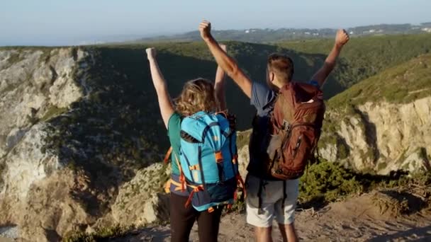 Couple de touristes avec des sacs à dos de camping debout à la falaise — Video