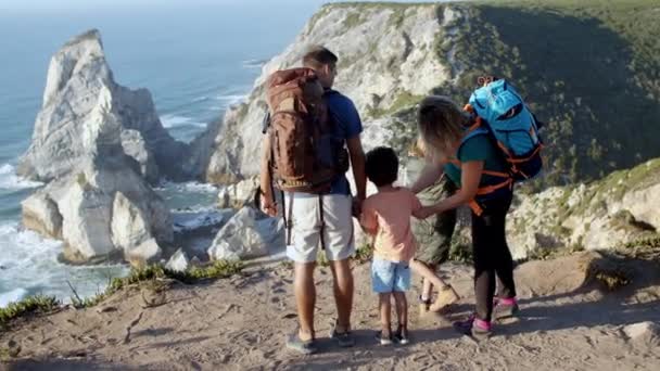 Pareja de padres activos con mochilas de camping y dos hijos — Vídeo de stock