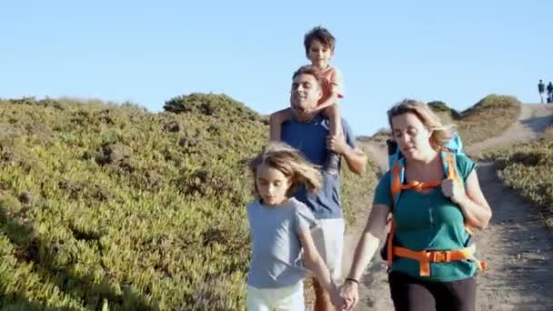 Couple de parents actifs et d'enfants marchant sur le chemin — Video