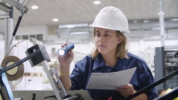 Técnico de fábrica feminino de idade média examinando a máquina — Vídeo de Stock