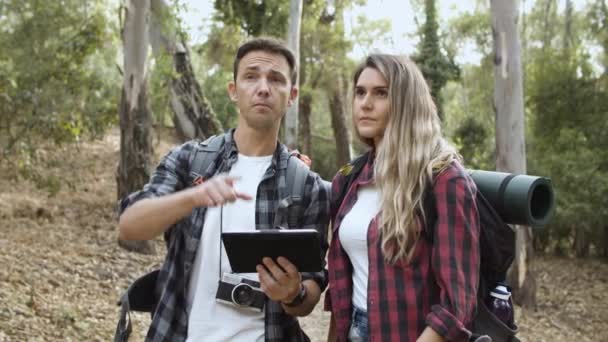 Ζευγάρι των νέων backpackers χρησιμοποιώντας δισκίο στο δάσος — Αρχείο Βίντεο