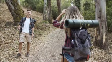 Fotoğraf makinesi olan turist kız erkek arkadaşının fotoğraflarını çekiyor.