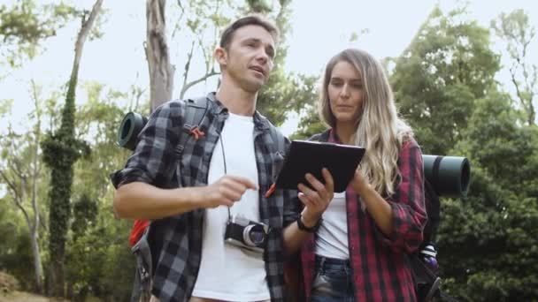 Ζευγάρι των νέων backpackers διαδρομή ελέγχου στο tablet — Αρχείο Βίντεο