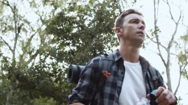 Yürüyüş yapan adam yolda tatlı su içiyor.