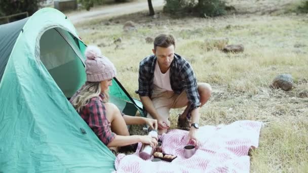 Camping couple eating breakfast, drinking tea or coffee — Stock Video