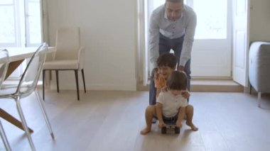 Komik baba evde oğullarıyla aktif oyunlar oynuyor.