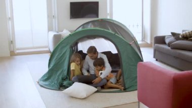 Baba ve çocuklar dizüstü bilgisayarda film izliyorlar.