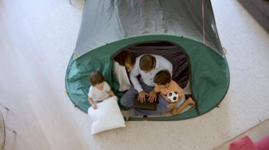 Babam ve üç çocuk oturma odasında kamp yapıyor.