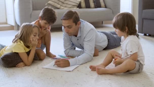 Enfants frères et sœurs et papa assis et couché sur le sol chaud — Video