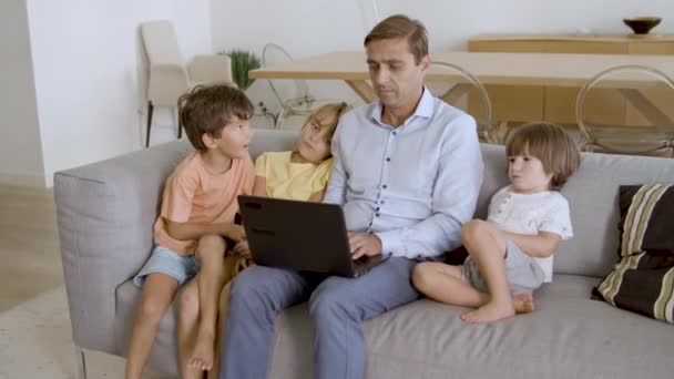 아버지와 세 명 의친 형제자매가 소파에서 쉬고 있다 — 비디오