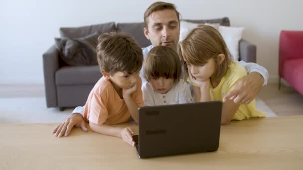즐거운 아버지가 노트북 컴퓨터를 사용하는 불쌍 한 아이들에게 이야기를 읽어 준다 — 비디오