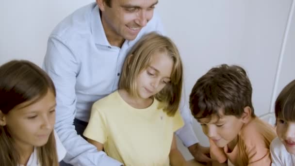 Glad pappa hjälper upphetsad dotter att skära festlig tårta — Stockvideo