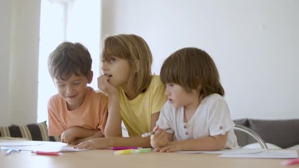 Oturma odasında keçeli kalemle resim yapan mutlu çocuklar. — Stok video
