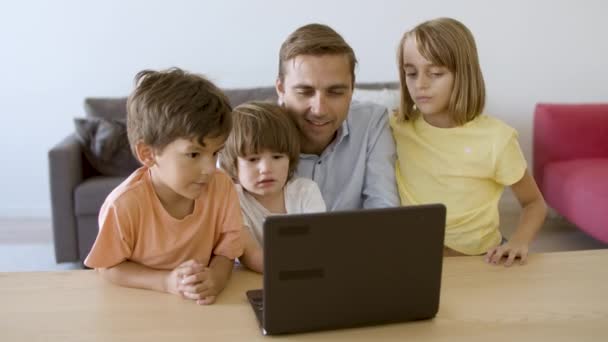 Caucásico papá viendo película a través de ordenador portátil con niños — Vídeos de Stock