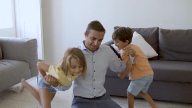 Kafkasyalı bir adam çocuklarla oynuyor ve güç gösteriyor.