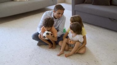 Babam çocuklara küçük futbol topları atmayı öğretiyor.