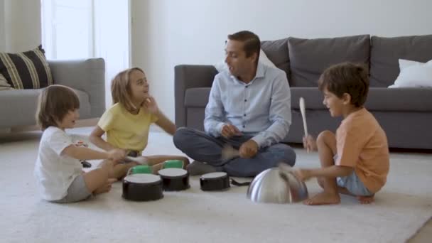 Enfants mignons et papa assis sur le tapis et jouer avec des ustensiles — Video