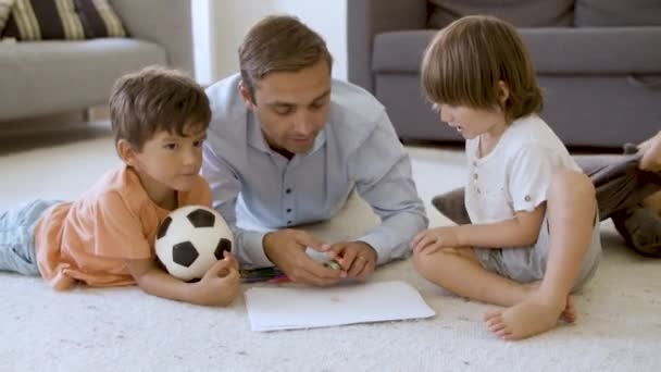 Enfants frères et sœurs et papa couchés sur le sol chaud — Video