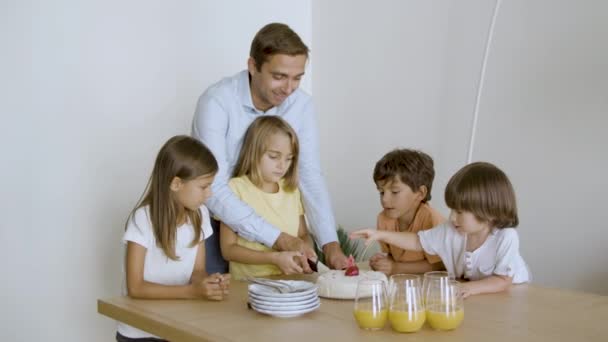 Pappa hjälper upphetsad dotter att skära festlig tårta — Stockvideo