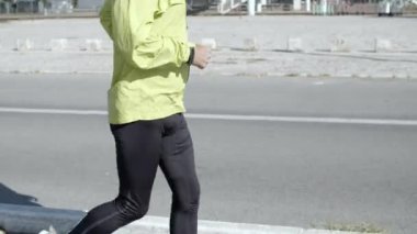 Dışarıda kulaklıkları olan aktif kıdemli koşucu.
