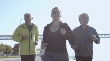 Bir grup aktif insan dışarıda birlikte antrenman yapıyor.