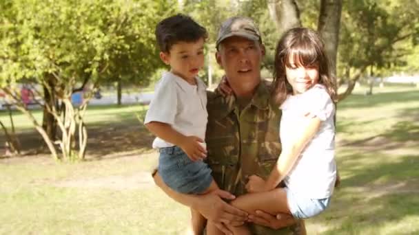Feliz padre militar sosteniendo a los niños en armas al aire libre — Vídeos de Stock