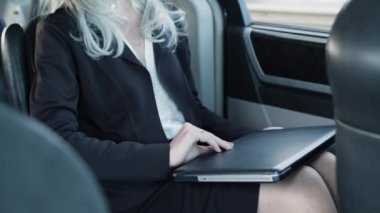 İş kadını araba kullanıyor ve laptop kullanıyor..