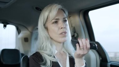 İş toplantısına giden ve sesli mesaj kaydeden kadın.