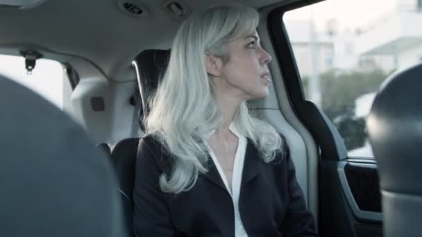 Bělošské šedovlasé ženy sedící na zadním sedadle jedoucího auta. — Stock video