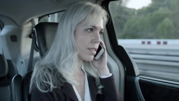 Žena mluví po telefonu při jízdě na obchodní schůzku. — Stock video