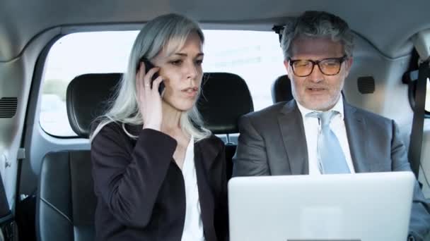 Femme parlant au téléphone et avec son partenaire en voiture — Video