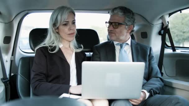 Forretningspartnere som samarbeider om bruk av bærbar datamaskin i bil. – stockvideo