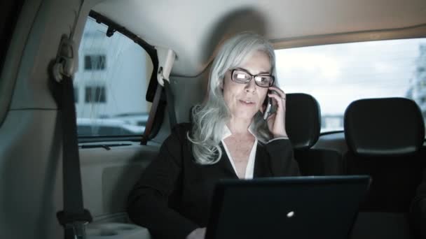 Καυκάσια επιχειρηματίας μιλάει στο τηλέφωνο ενώ οδηγεί το αυτοκίνητο. — Αρχείο Βίντεο