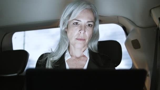 Poważny biały bizneswoman pracuje na laptopie w samochodzie — Wideo stockowe