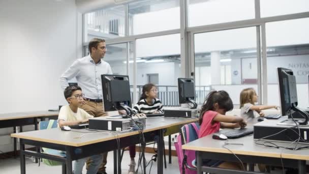 Datavetenskapslärare tittar på elever som gör uppgift. — Stockvideo