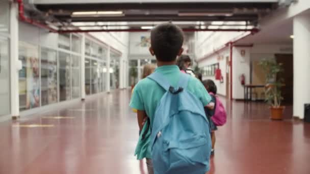 Κοντινό πλάνο του αγοριού με τα γυαλιά περπατώντας προς τους συμμαθητές του. — Αρχείο Βίντεο