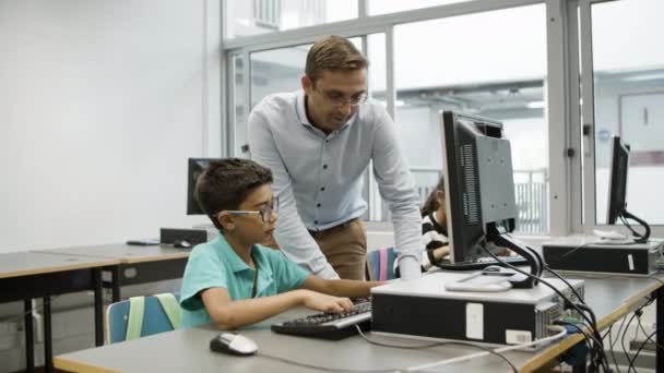 Junge mit Brille fragt Lehrer nach Computerarbeit. — Stockvideo