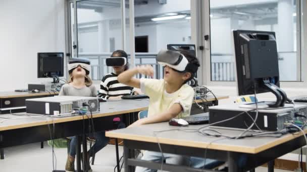 Kinder sitzen im Klassenzimmer und nutzen Virtual-Reality-Headset. — Stockvideo