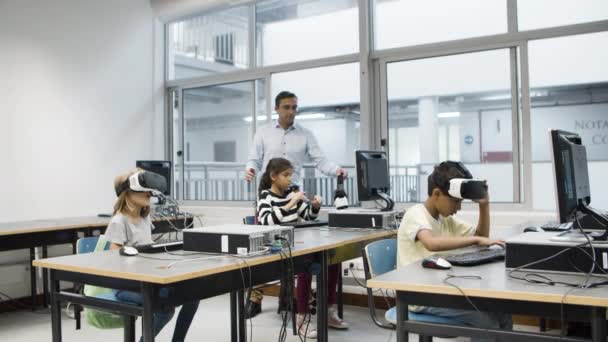 Učitel se dívá, jak děti používají VR brýle. — Stock video